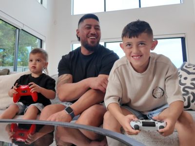 Une famille joue à des jeux vidéo ensemble à la maison ; une stratégie parentale positive visant à prévenir la dépendance aux jeux vidéo chez les enfants.